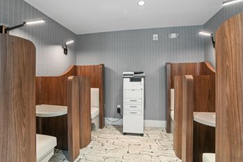a bathroom with four stalls and a toilet and a sink